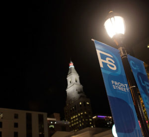 streetlamp lit at night with banners labeled '"Front Street" hanging