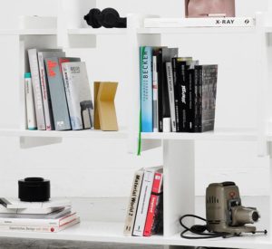 modern white bookshelves with books and other various items